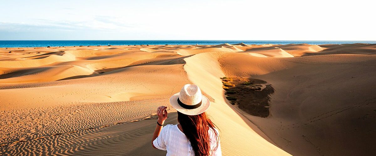 Tourist exploring Maspalomas dunes, Grand Canary, Canary Islands