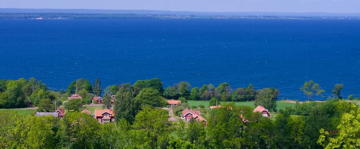View over a rural lush landscape and the blue lake Vättern in S