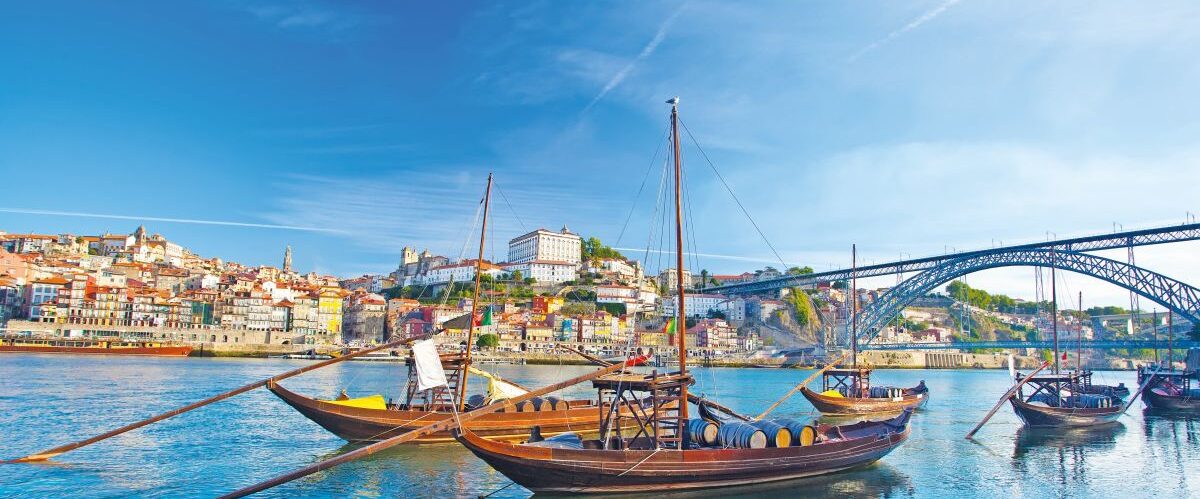 Old,Porto,And,Traditional,Boats,With,Wine,Barrels,,Portugal